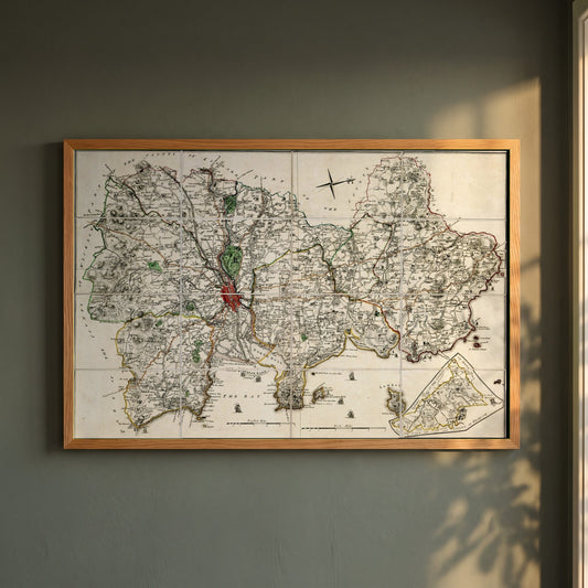 Map of County Dublin framed print in a natural oak frame on a dark green wall beside a window, dappled plant shadow