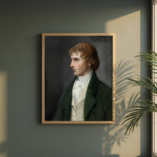 Henry Joy McCracken framed print in a natural oak frame on a dark green wall beside a window, dappled plant shadow