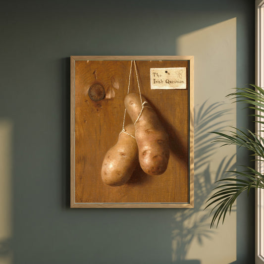 The Irish Question framed print in a natural oak frame on a dark green wall beside a window, dappled plant shadow