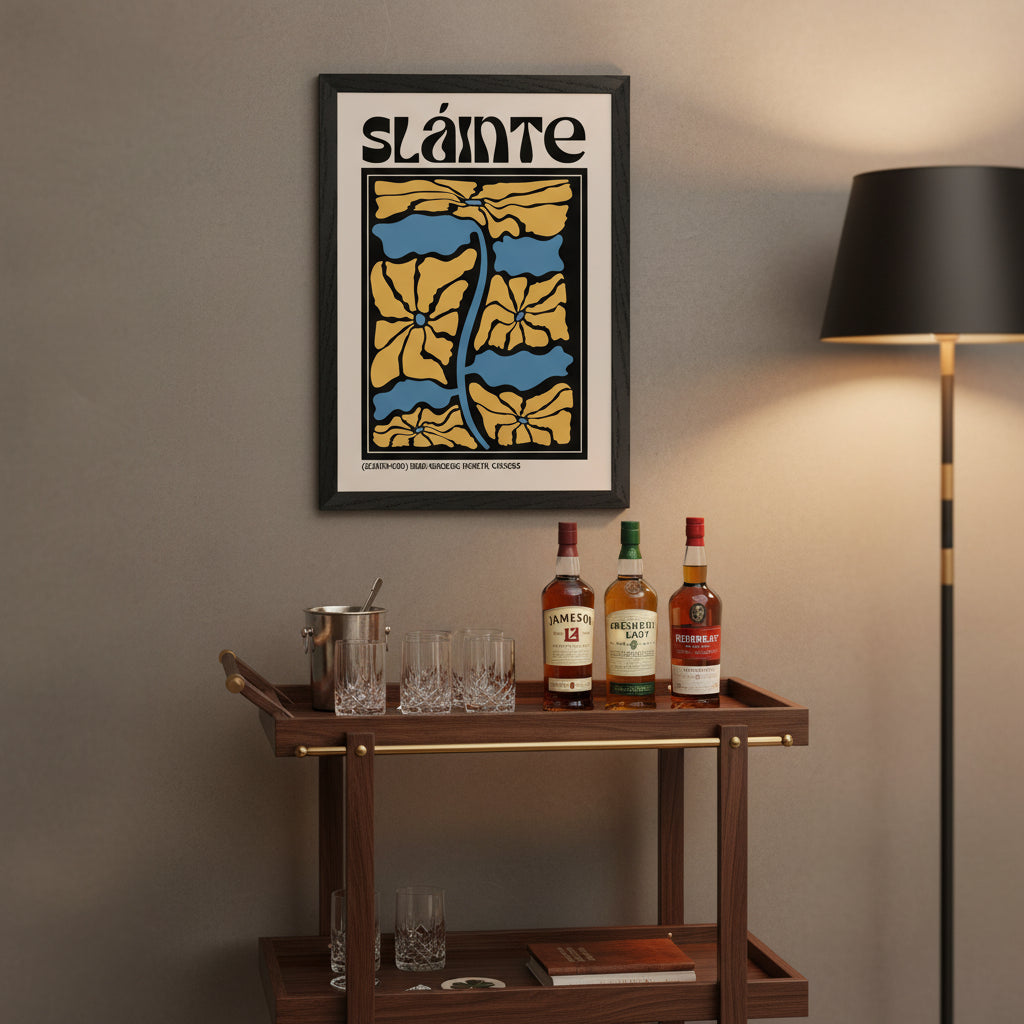 Framed Sláinte print hanging above a wooden bar cart with glasses, whiskey bottles, and soft warm lighting. Premium lifestyle shot.
