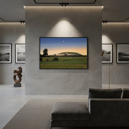 Newgrange framed print: A depiction of the ancient Irish monument, showcasing its intricate carvings and timeless aura. Black frame variant hung in a modern collector’s loft with stone wall texture, spot lighting, and Irish landscape photography nearby — refined, luxurious interior.