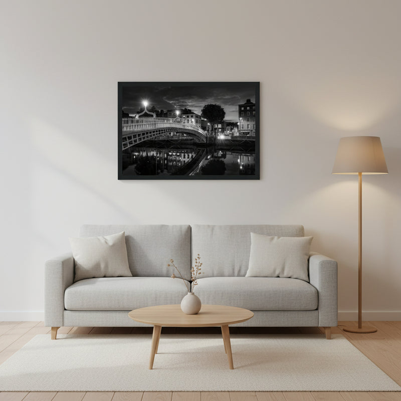 Black and white framed wall art print of Dublin's iconic Ha'penny Bridge at night. The detailed photograph captures the bridge's intricate architecture and its reflection in the River Liffey, creating a timeless and elegant piece perfect for home or office decor