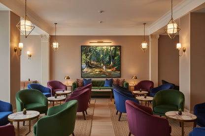 Boutique hotel lounge interior, understated luxury design, textured walls, plush seating, warm ambient lighting, Sir John Lavery Collector’s Edition art print The Path by the River, Maidenhead framed in black wood, professional hospitality interior photography, refined and timeless aesthetic