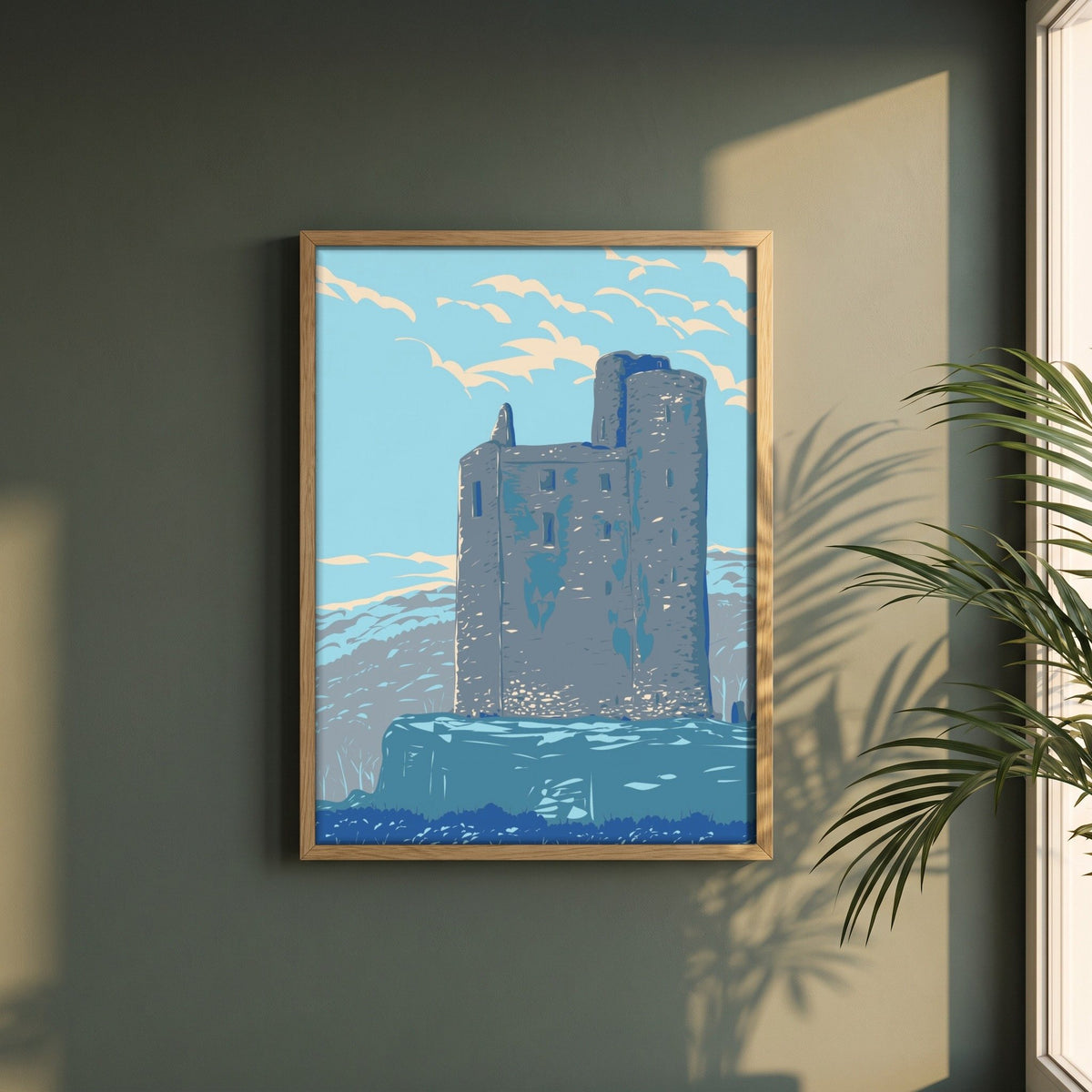 Ballinalacken Castle, County Clare retro travel print in a natural oak frame on a dark green wall beside a window, dappled plant shadow