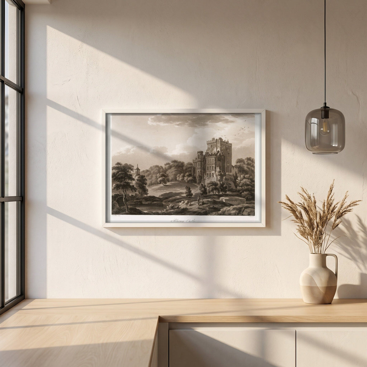 Blarney Castle 1796 by Thomas Sautelle Roberts Art Print framed print in a white frame on a plaster wall above an oak worktop in a bright Scandinavian kitchen