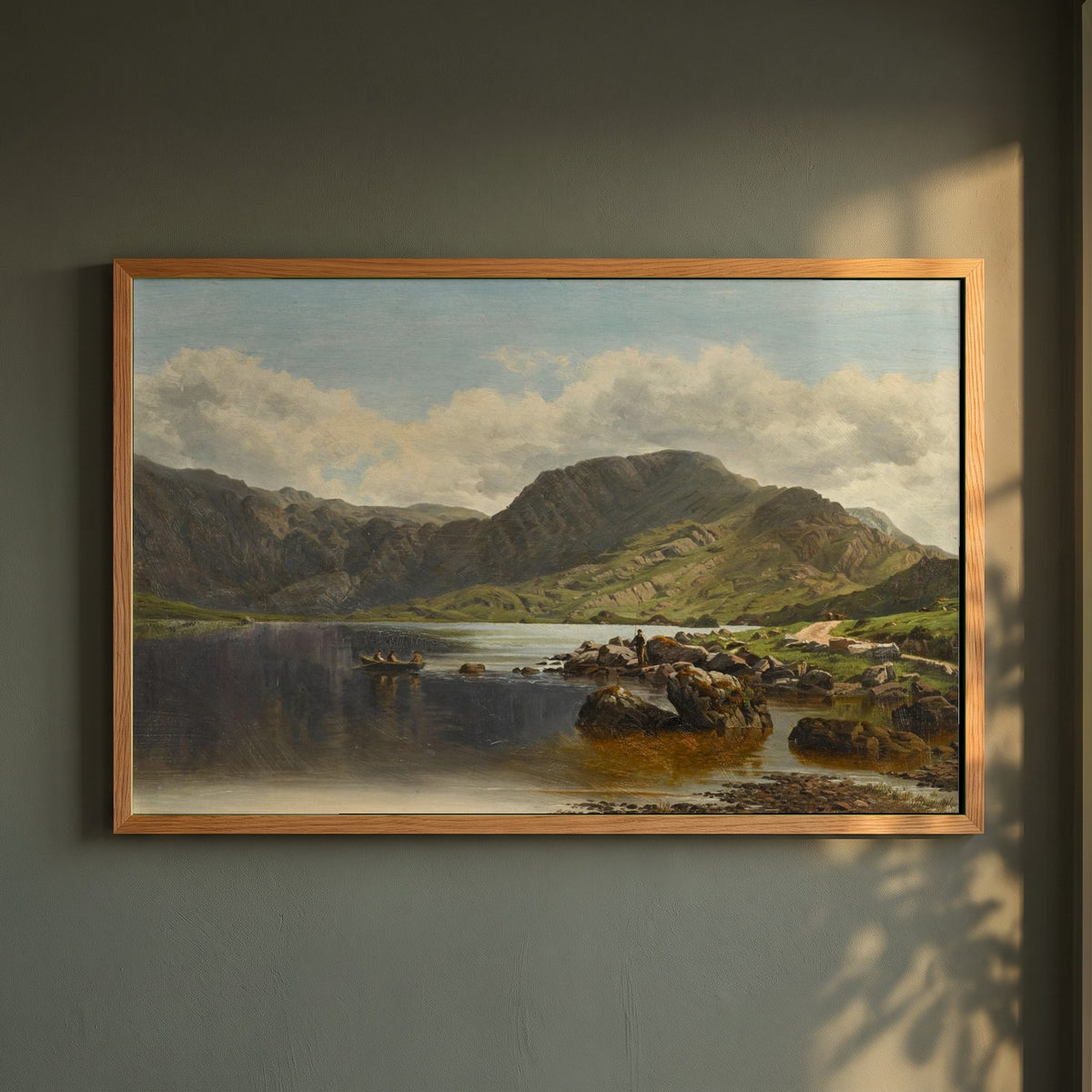 Cloon Lake, Glencar, Co. Kerry framed print in a natural oak frame on a dark green wall beside a window, dappled plant shadow
