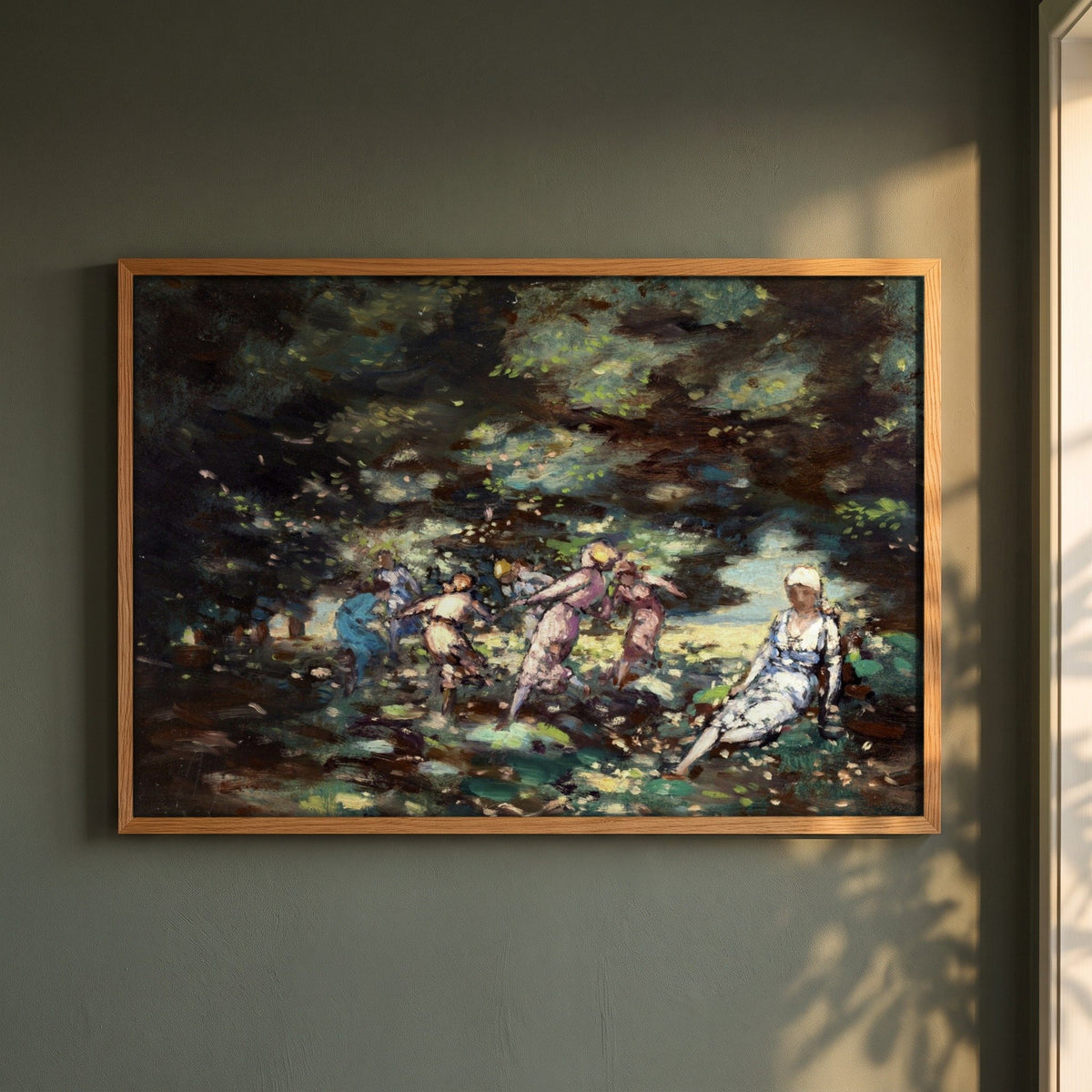 Fairies in a Wood by George Russell (Æ) framed print in a natural oak frame on a dark green wall beside a window, dappled plant shadow