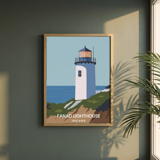Fanad Head Lighthouse Framed Print | Donegal framed print in a natural oak frame on a dark green wall beside a window, dappled plant shadow
