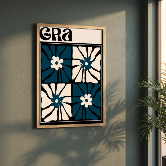 Grá framed print in a natural oak frame on a dark green wall beside a window, dappled plant shadow