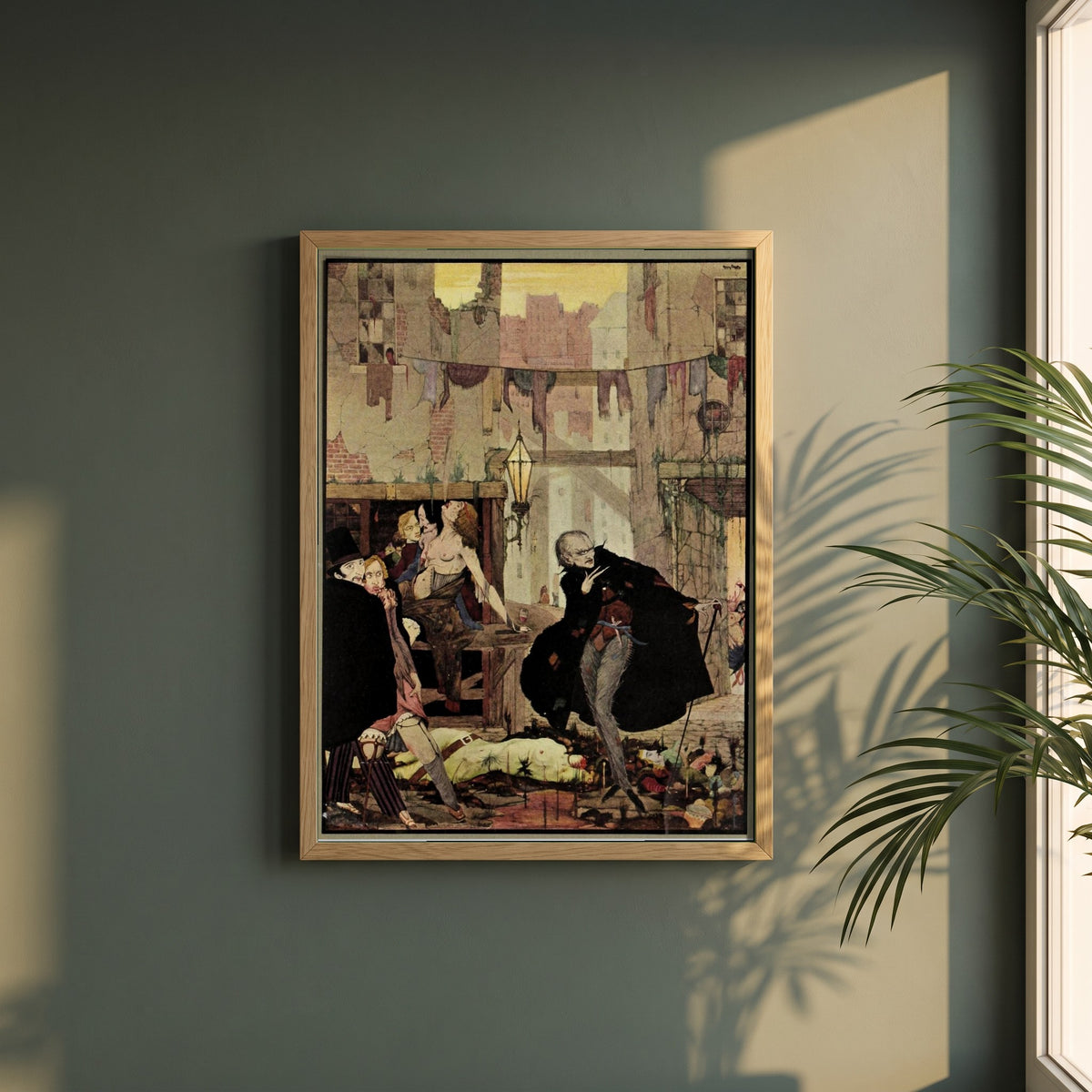 Harry Clarke framed print in a natural oak frame on a dark green wall beside a window, dappled plant shadow