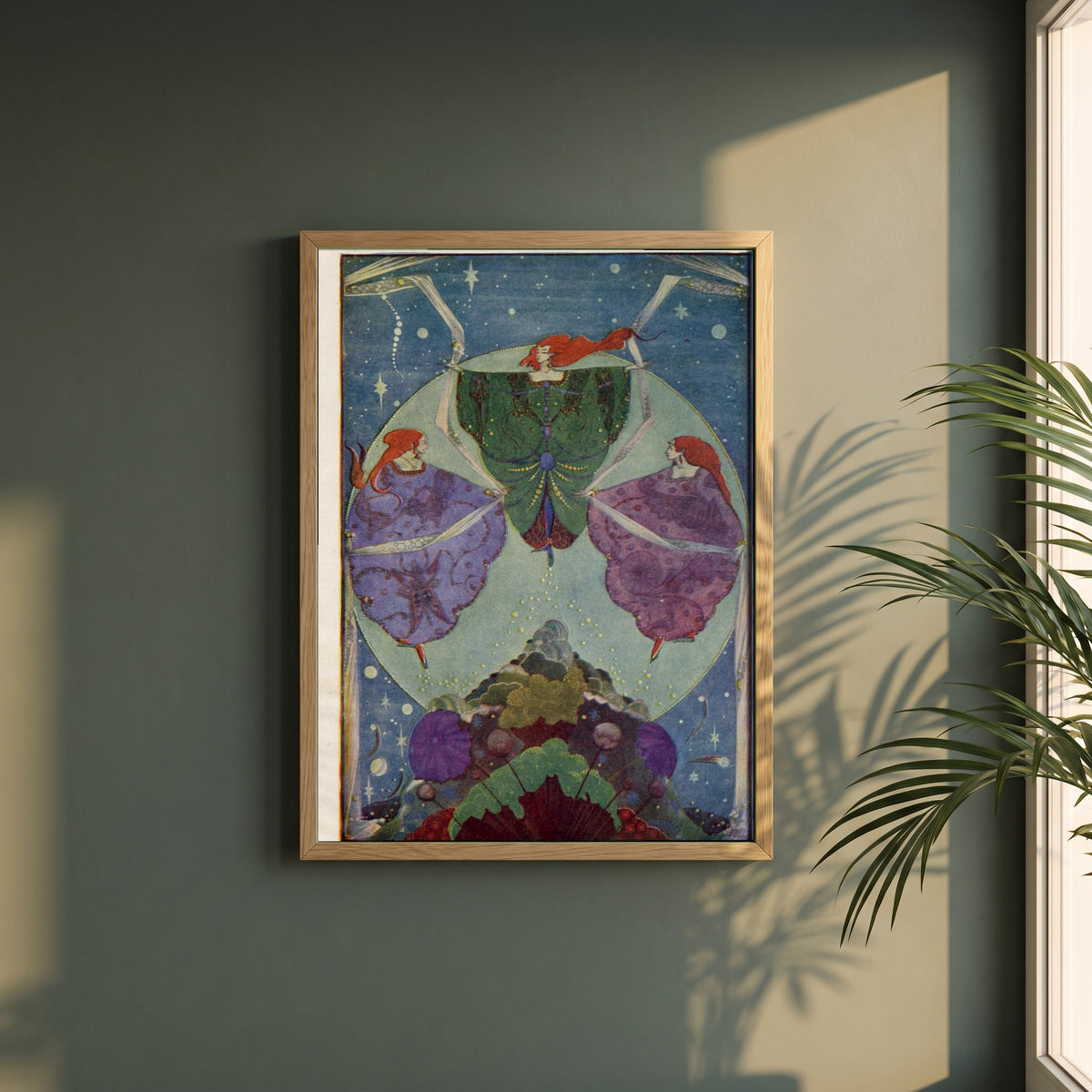 Harry Clarke framed print in a natural oak frame on a dark green wall beside a window, dappled plant shadow