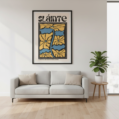 Sláinte Irish cheers print in a black frame above a grey sofa and potted plant in a bright room