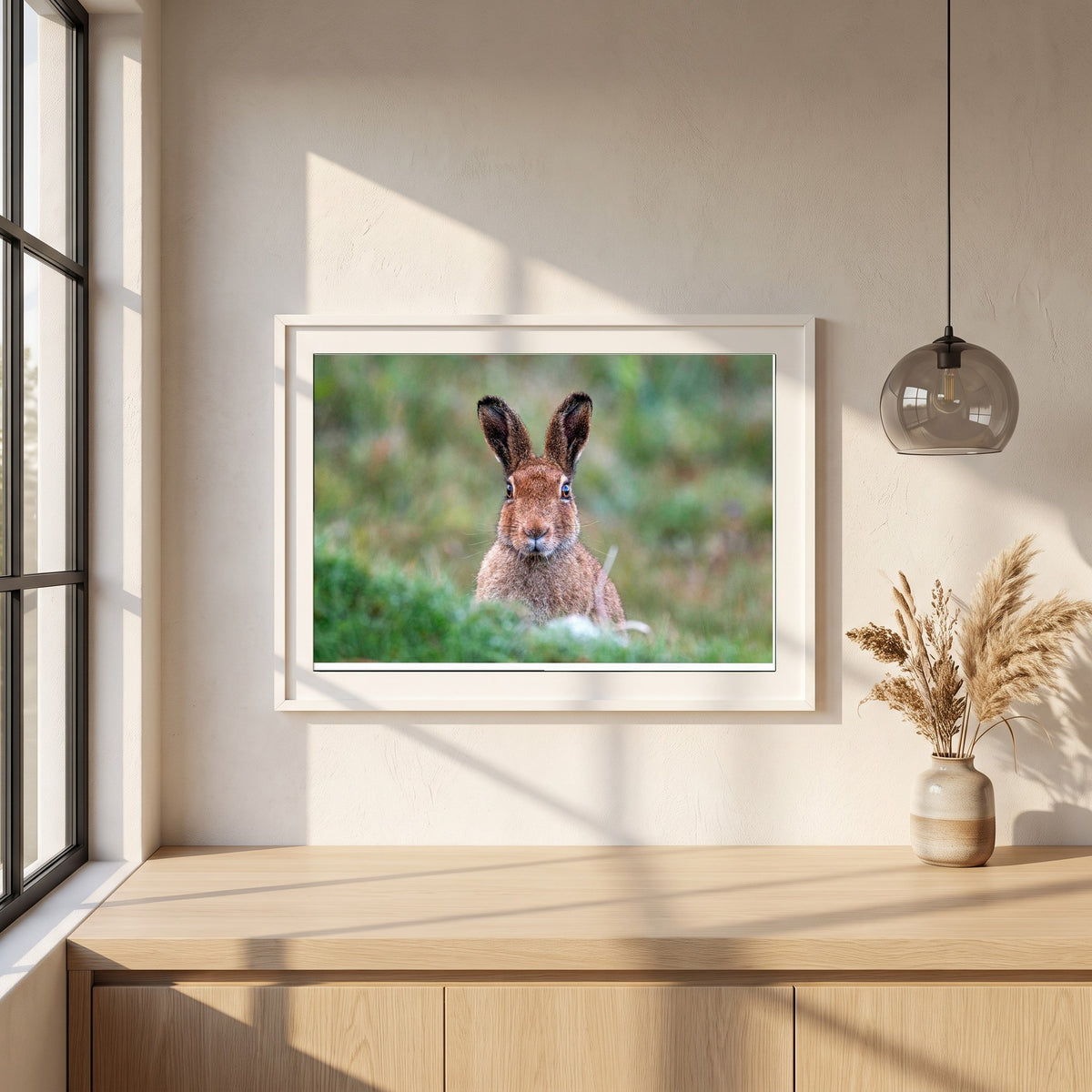 Irish Hare framed print in a white frame on a plaster wall above an oak worktop in a bright Scandinavian kitchen
