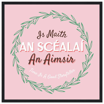 Is Maith an Scéalaí an Aimsir pink typography print in a slim black frame on a white background