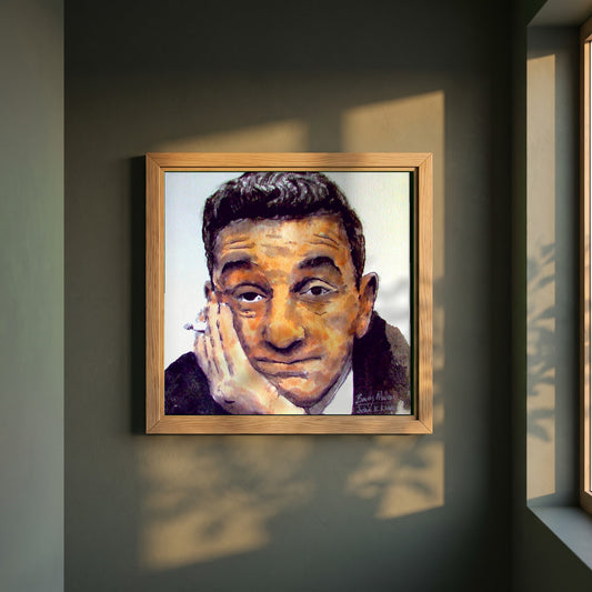 John B. Keane framed print in a natural oak frame on a dark green wall beside a window, dappled plant shadow