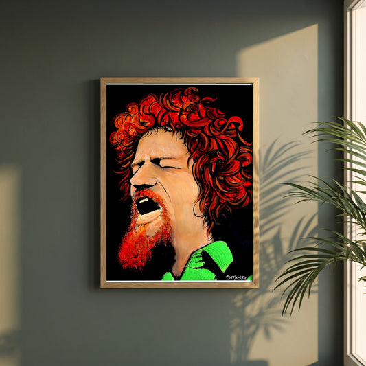 Luke Kelly framed print in a natural oak frame on a dark green wall beside a window, dappled plant shadow