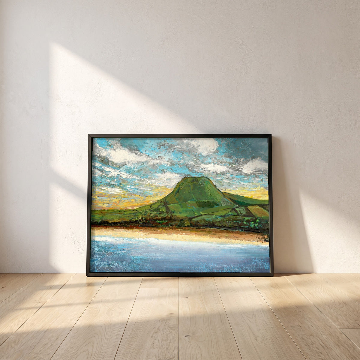 Lurig Mountain at Sunset framed print in a black frame leaning against a white plaster wall on oak floorboards in morning light