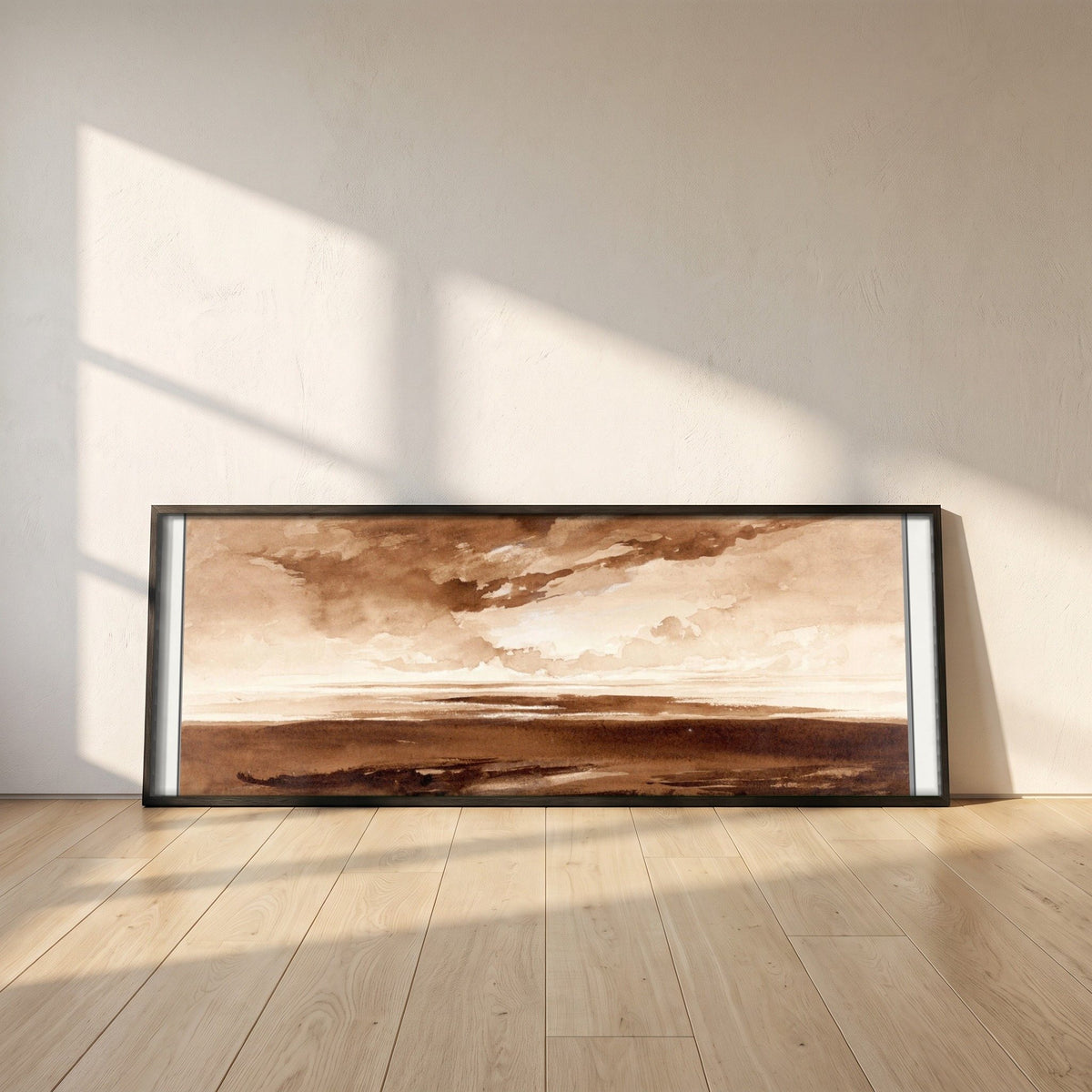 Panorama of the Coast at Sunset framed print in a black frame leaning against a white plaster wall on oak floorboards in morning light