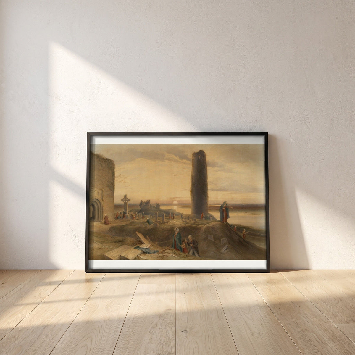 The Last Circuit of Pilgrims at Clonmacnoise by George Petrie framed print in a black frame leaning against a white plaster wall on oak floorboards in morning light