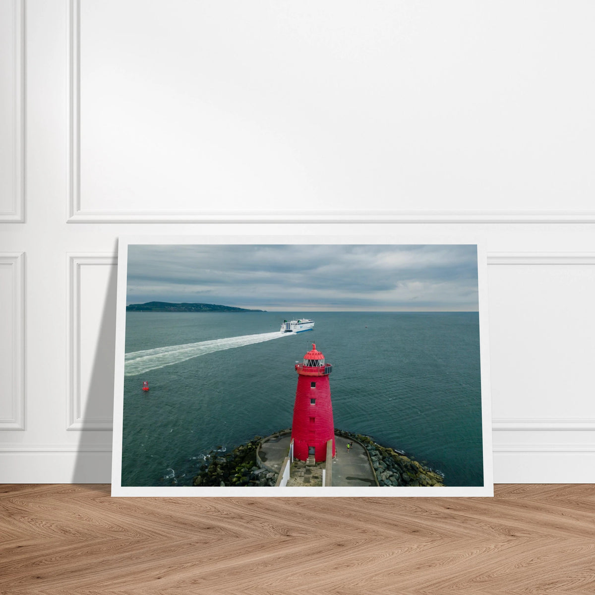 Poolbeg Lighthouse, Dublin Bay photo in a white frame, leaning on a wooden floor, straight-on view