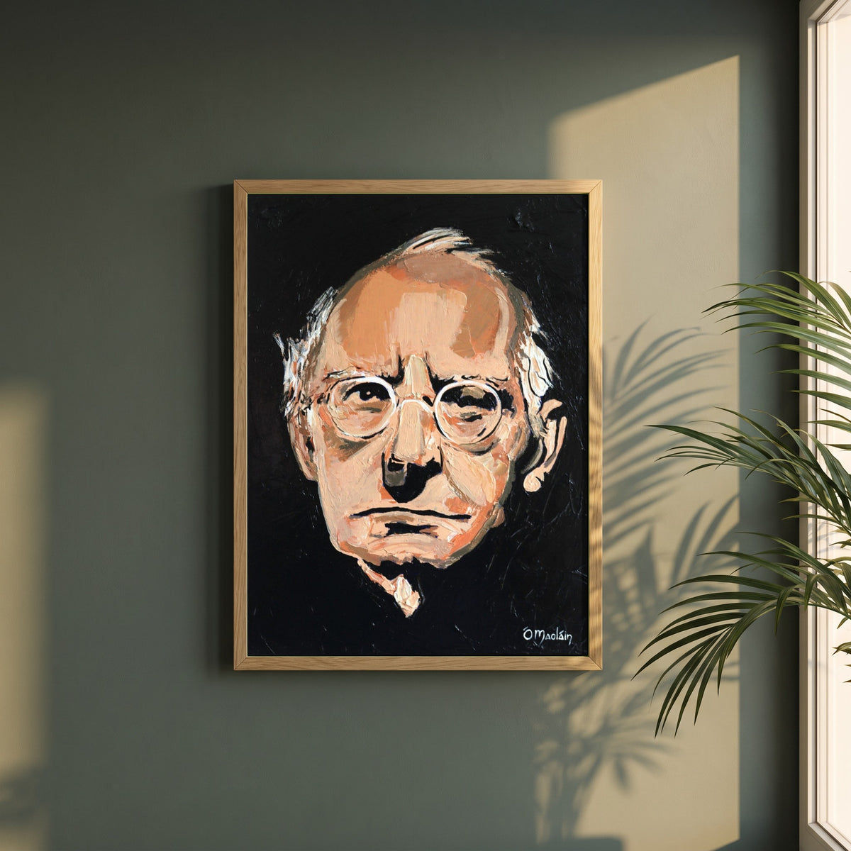 Sean O'Casey framed print in a natural oak frame on a dark green wall beside a window, dappled plant shadow