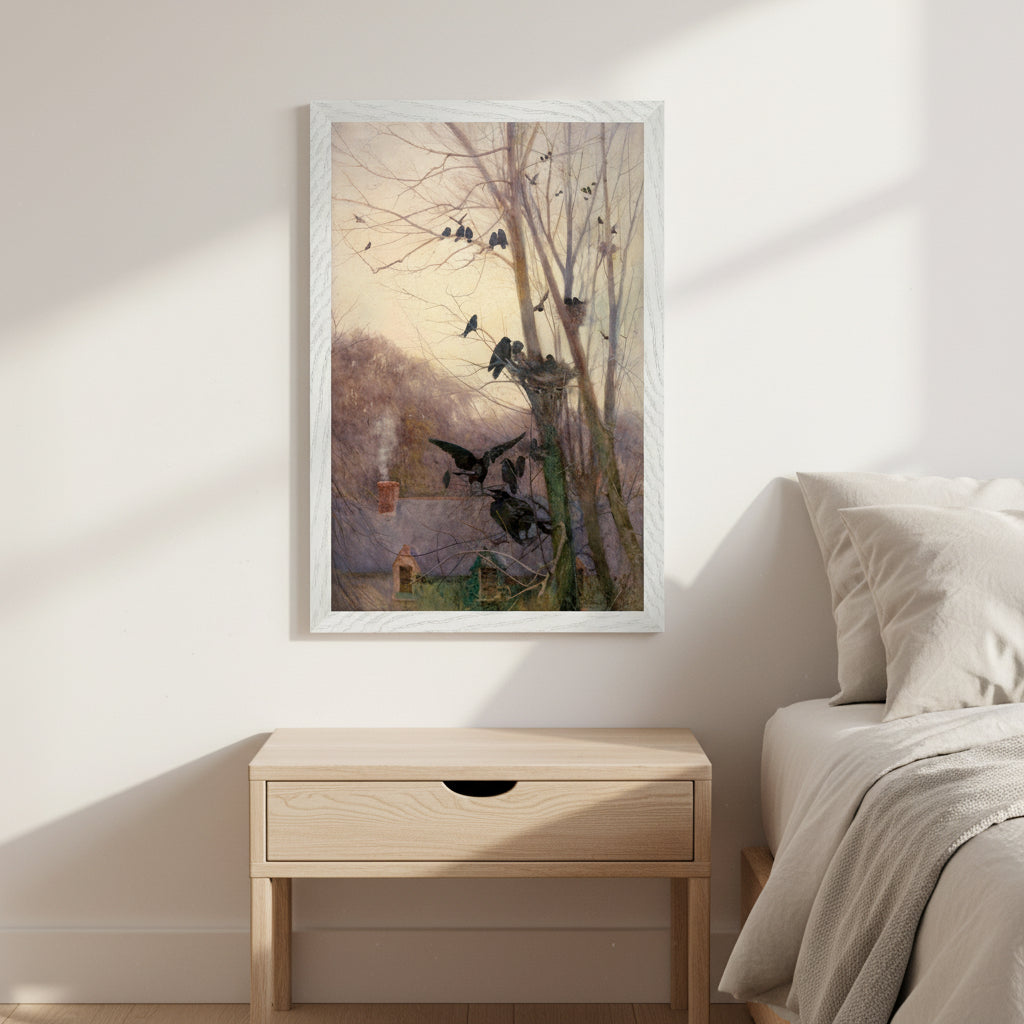 Shades of Evening by Mildred Anne Butler, 30x45 cm in white wooden frame mounted on a warm off-white wall in a calm bedroom interior. Linen bedding, light wood bedside table, warm morning light, soft shadows. Artwork shows an Irish cottage scene with rooks in leafless trees at dusk. Premium, serene, airy aesthetic.