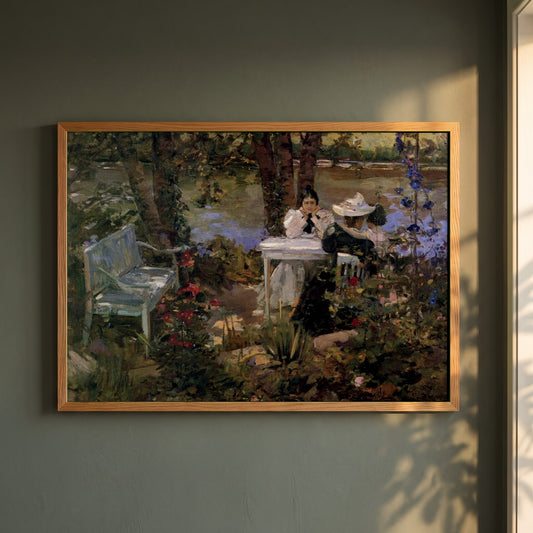 A Garden in France framed print in a natural oak frame on a dark green wall beside a window, dappled plant shadow