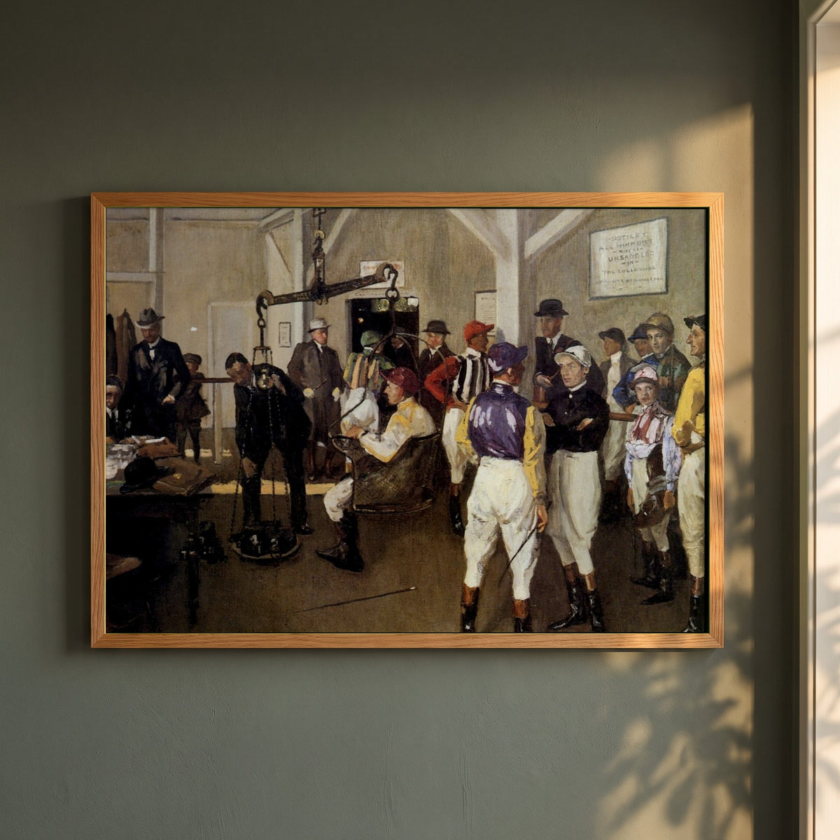 The Weighing Room, Hurst Park framed print in a natural oak frame on a dark green wall beside a window, dappled plant shadow