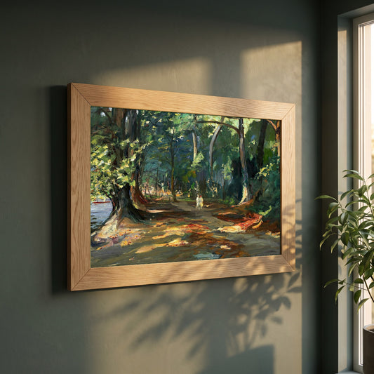 The Path framed print in a natural oak frame on a dark green wall beside a window, dappled plant shadow