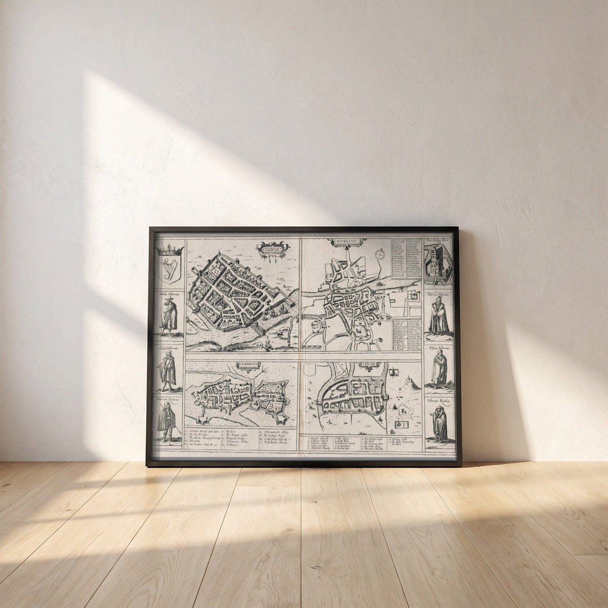 Town Plans of Dublin, Cork, Limerick & Galway 1618 framed print in a black frame leaning against a white plaster wall on oak floorboards in morning light