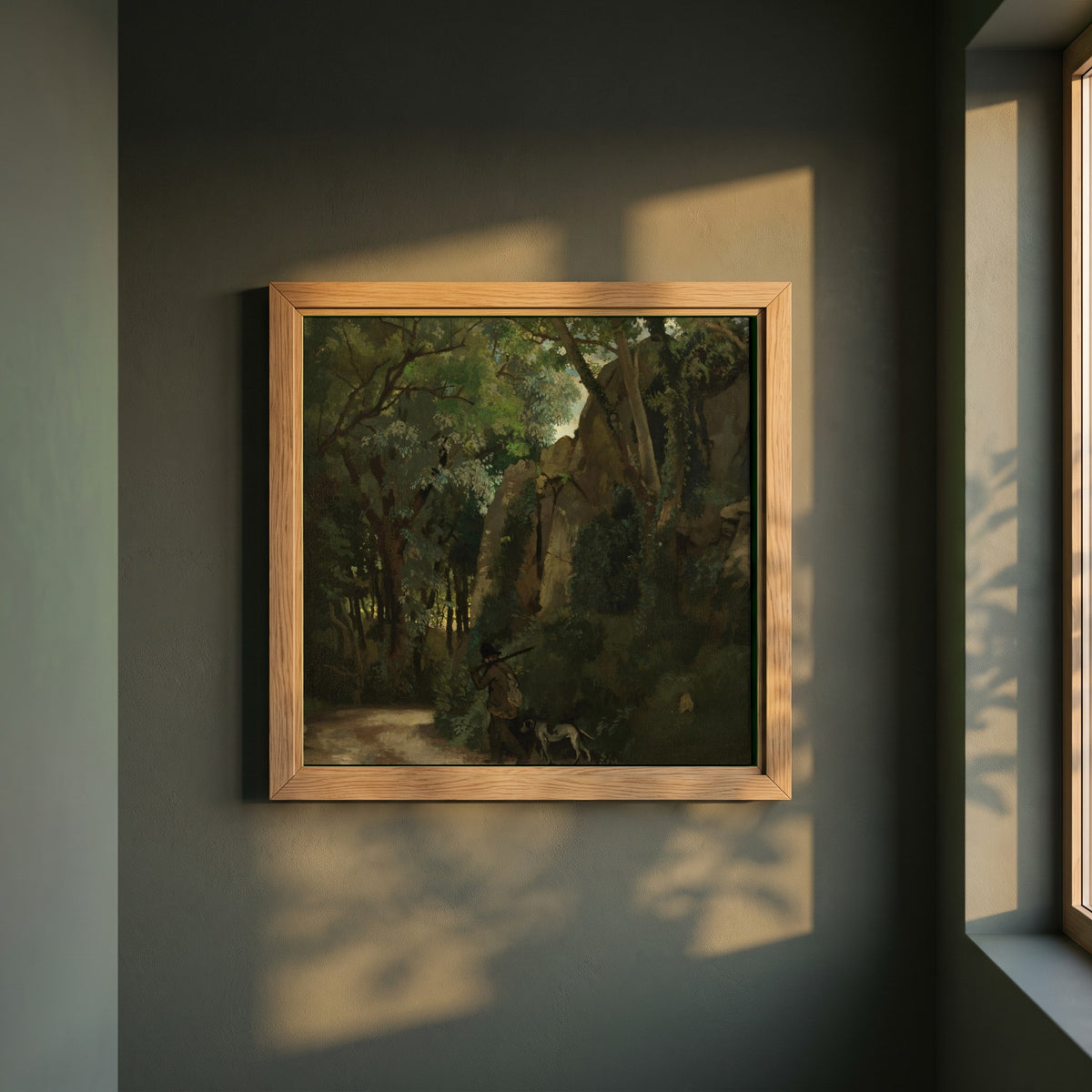 Trees at Howth framed print in a natural oak frame on a dark green wall beside a window, dappled plant shadow