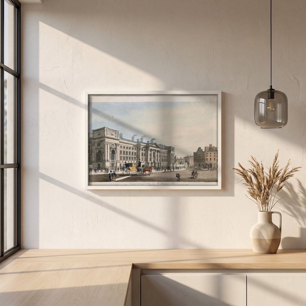 Trinity College Dublin from Westmoreland Street framed print in a white frame on a plaster wall above an oak worktop in a bright Scandinavian kitchen